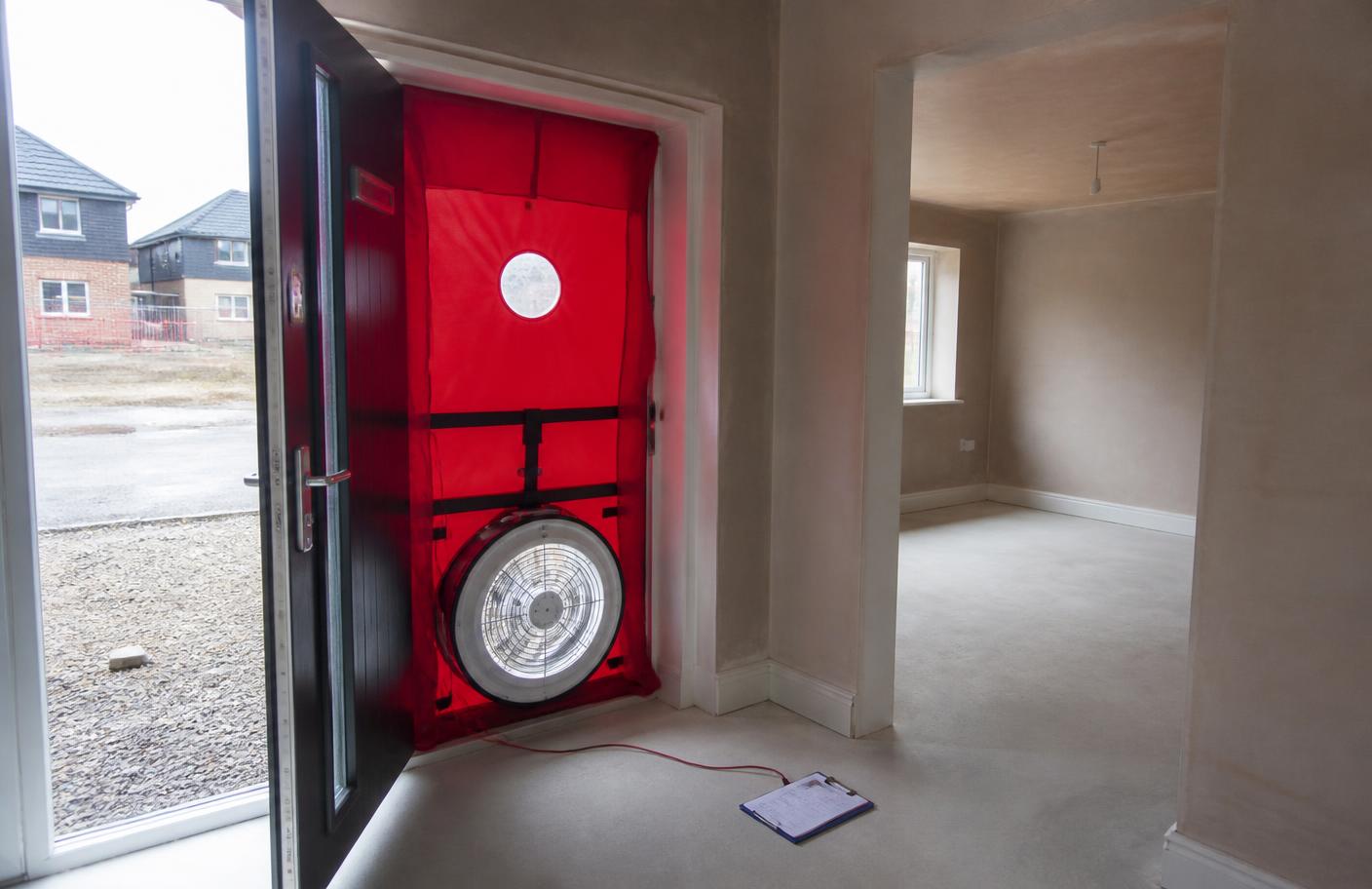 Blower door fan sealed into the doorway of a newly built house for an air tightness test